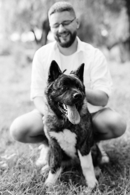 Perro grande a pasear con un chico y una chica en la pradera verde