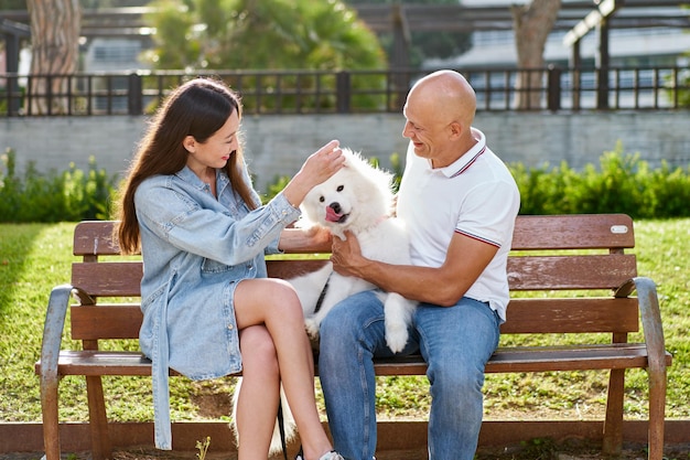 Perro samoyedo con su dueña en el parque jugando juntos