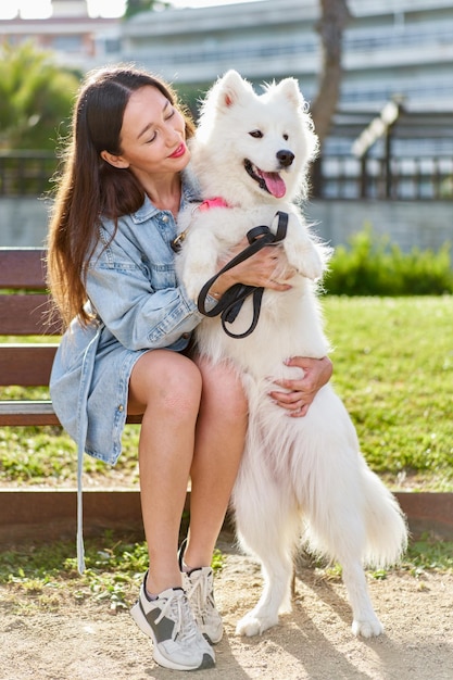 Foto perro samoyedo con su dueña en el parque