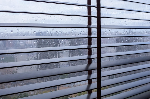 Persianas metálicas en las ventanas cuando llueve en interiores