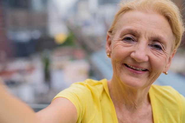 Persönlicher Standpunkt der älteren Frau, die selfie mit Handy nimmt