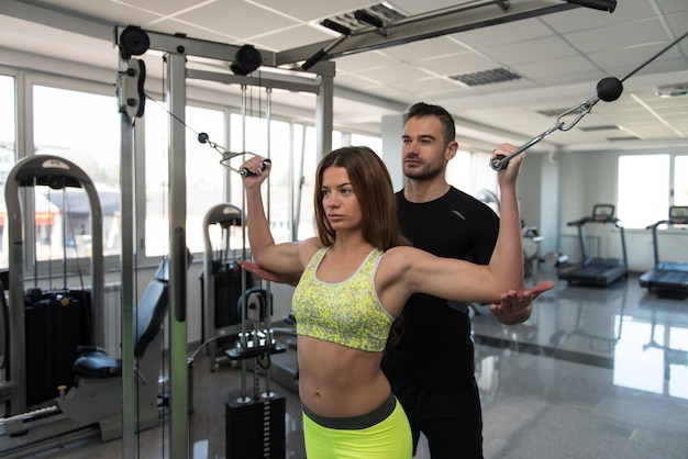 Persönlicher Trainer hilft Kunden im Fitnessstudio