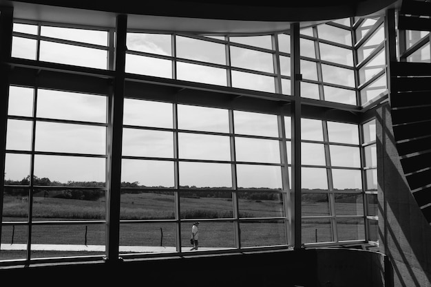 Foto persönlichkeit, die durch ein fenster auf dem feld gegen den himmel läuft