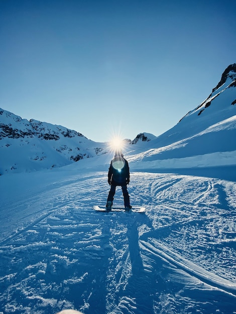 Person auf einem schneebedeckten Berg gegen den Himmel