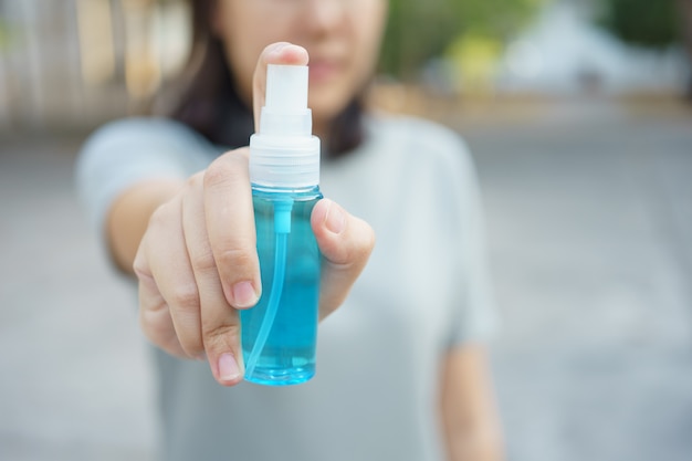 Person, die Alkoholflasche sprüht