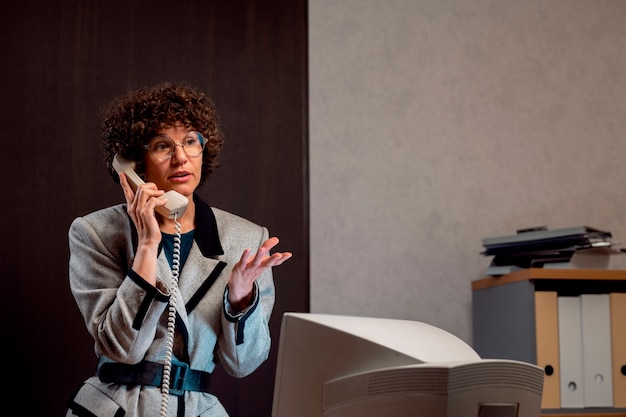 Foto person, die an einem schreibtisch im büro im stil der 90er jahre arbeitet