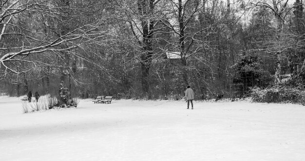 Foto person, die auf einem schneebedeckten feld geht