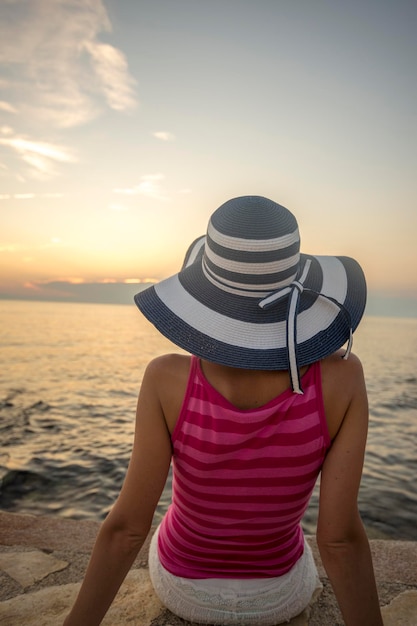 Person, die auf Felsen nahe Wasser sitzt