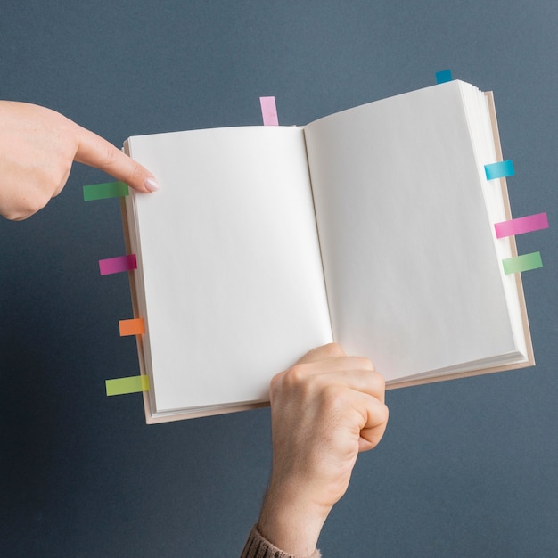 Foto person, die buch mit bunten erinnerungsaufklebern hält