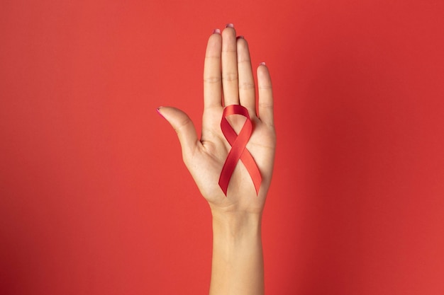 Person, die ein Bandsymbol zum Welt-Aids-Tag hält