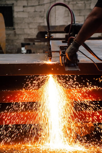 Person, die eine CNC-Autogen-Schneidemaschine verwaltet, die eine Stahlplatte schneidet