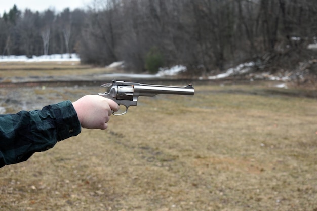 Foto person, die eine waffe hält