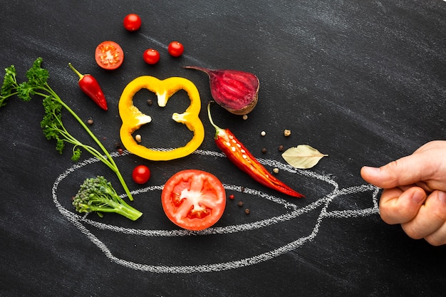 Foto person, die gemüse auf kreidewanne kocht