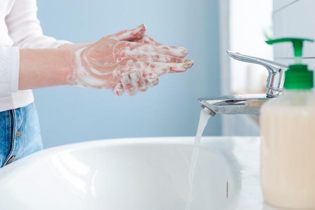 Foto person, die ihre hände mit wasser und seife wäscht