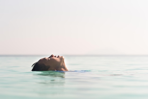 Person, die im Meer gegen klaren Himmel schwimmt