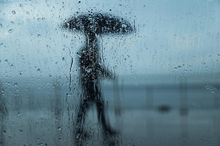 Foto person, die in der regenzeit durch ein nasses glasfenster gesehen wird