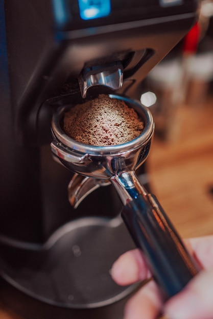 Person, die Kaffeemaschine im Café benutzt