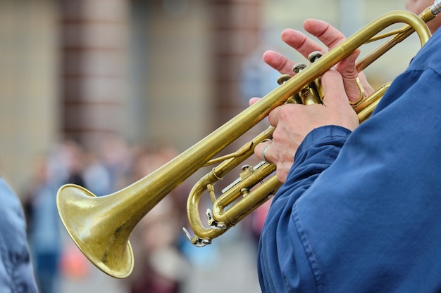 Foto person, die musik auf einer trompete in der straße spielt