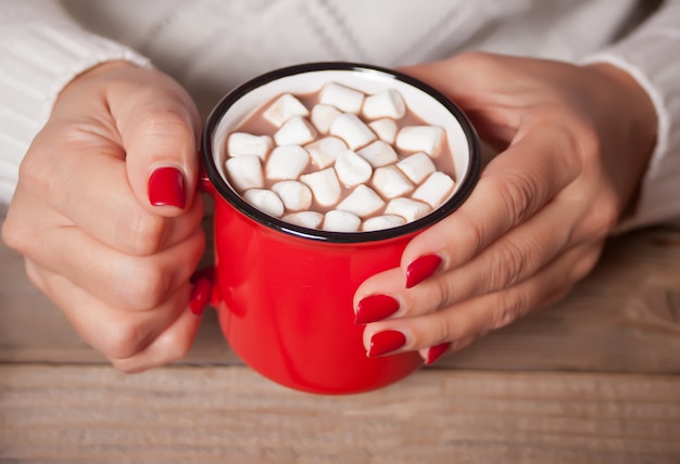 Person, die roten Becher Weihnachtskakao mit Eibischen hält