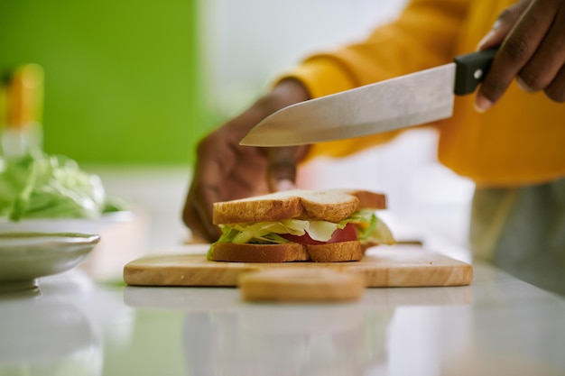 Person, die vegetarisches Sandwich schneidet