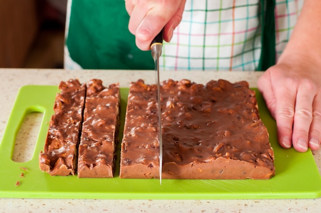 Foto person, die weihnachtsschokoladenfondant schneidet