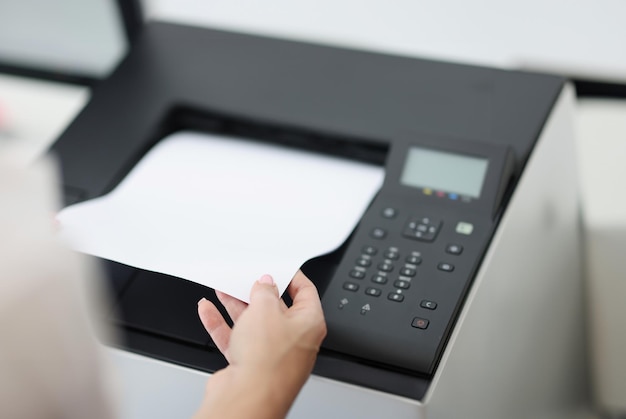 Foto person holt weißes blatt aus laserdrucker