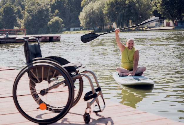 Person mit einer körperlichen Behinderung fährt auf einem SUP-Board