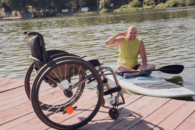 Person mit einer körperlichen Behinderung fährt auf einem SUP-Board