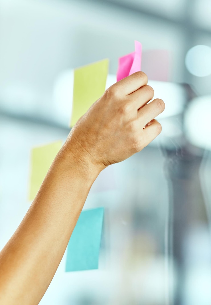 Foto person mit händen und klebrigen notizen auf glas zum schreiben von ideen planung oder zeitplanung verwaltung des startup-wachstums mitarbeiterpapier und kreative agenda inspiration zitat oder produktivitätslösung im büro