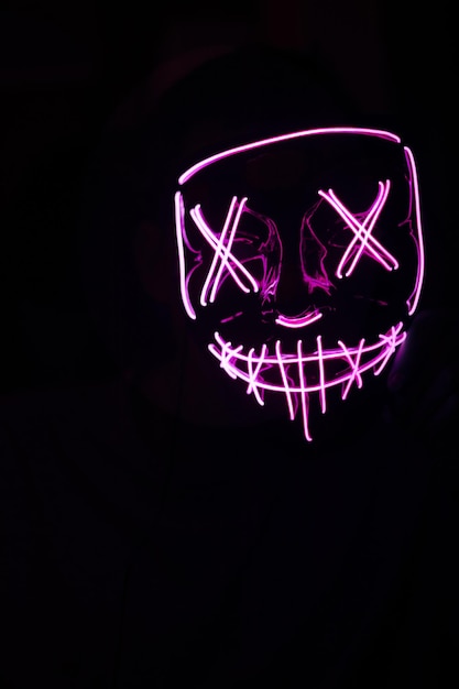 Person mit rosa LED-Maske zum Feiern