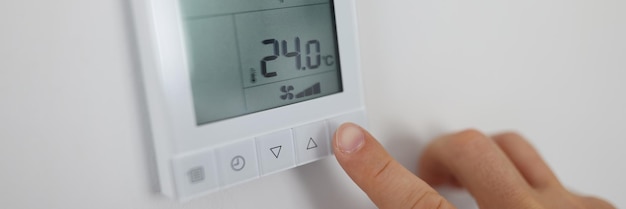 Person regelt die Lufttemperatur im Raum durch Fernbedienung am Wandklimakonzept