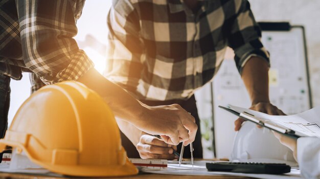 Person's Engineer Hand Drawing Plan On Blue Print with Architect Equipment Architekten diskutieren am Tisch über Teamarbeit und Workflow-Konstruktionskonzept