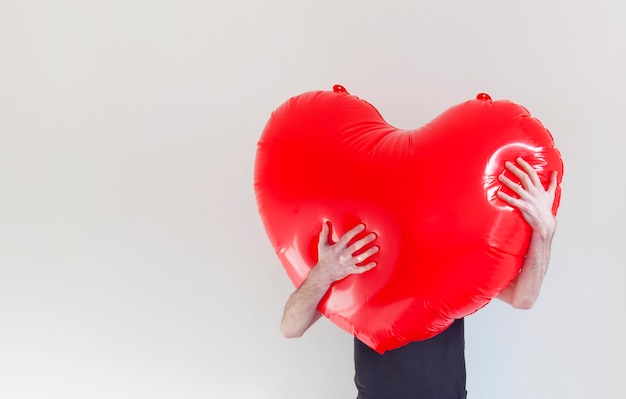 Una persona abraza un gran corazón de amor inflable rojo Concepto de salud y amor