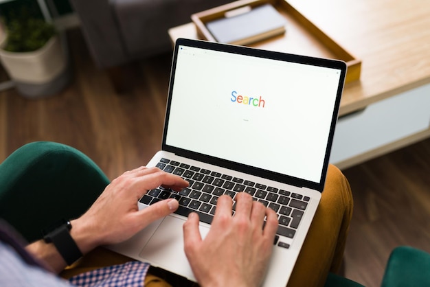 Persona adulta escribiendo una búsqueda de palabras en una barra de sitio web en su computadora portátil. Hombre en línea con un motor de búsqueda