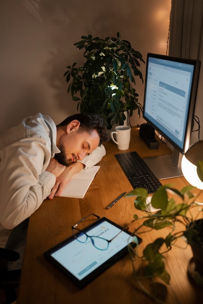 Persona adulta que trabaja tarde en la noche desde casa