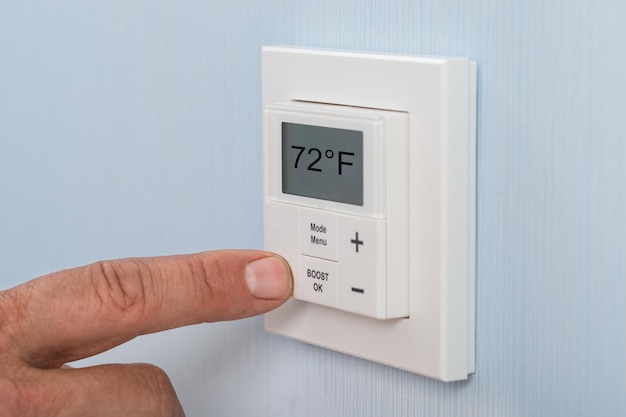 Persona ajustando la temperatura del termostato
