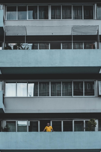 Foto persona apoyada en la terraza de un edificio foto