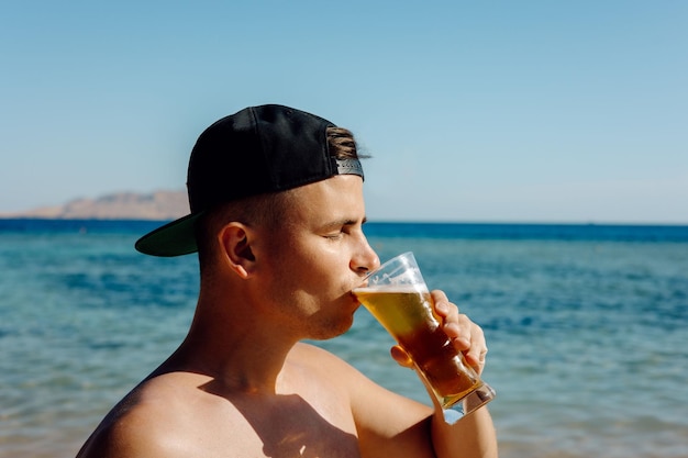 Persona bebiendo un vaso de cerveza en el mar retrato hombre bebiendo cerveza en verano