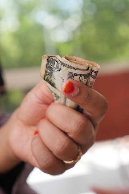 Una persona con un billete de un dólar en primer plano