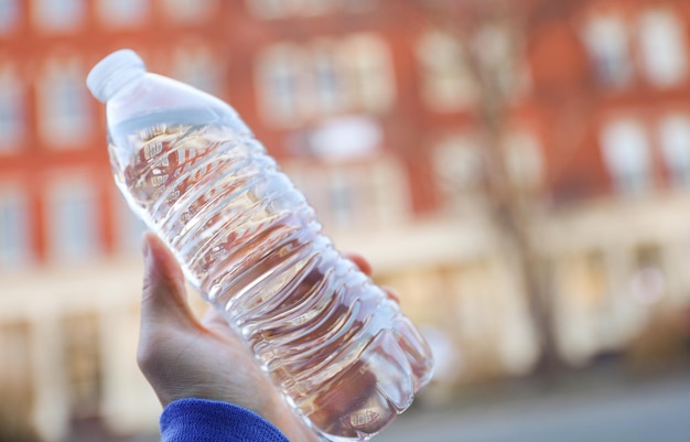 Una persona con una botella de agua en la mano.