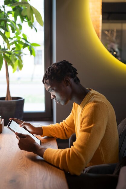 Persona en un cafe leyendo un libro electrónico