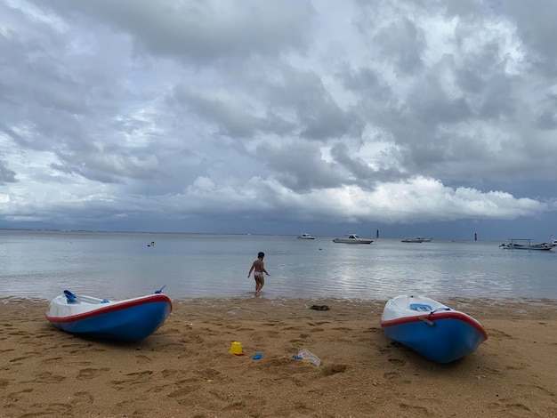 Una persona camina por la playa frente a un bote que dice 'soy una playa'