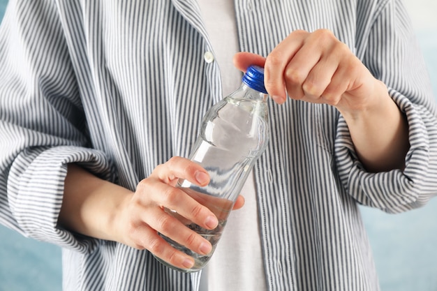 Persona en camisa abre una botella, cerrar