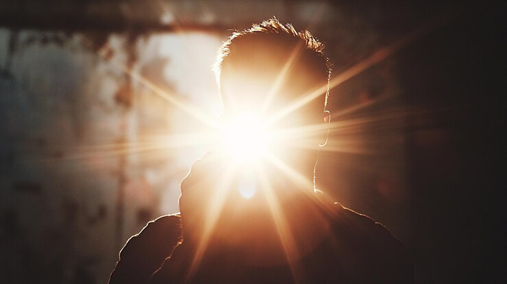 Persona captura luz brillante mientras toma una foto en un entorno oscuro