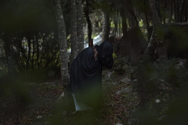 Foto persona con la cara cubierta en el bosque