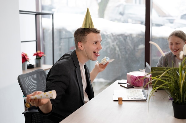 Foto persona celebrando un cumpleaños en la oficina