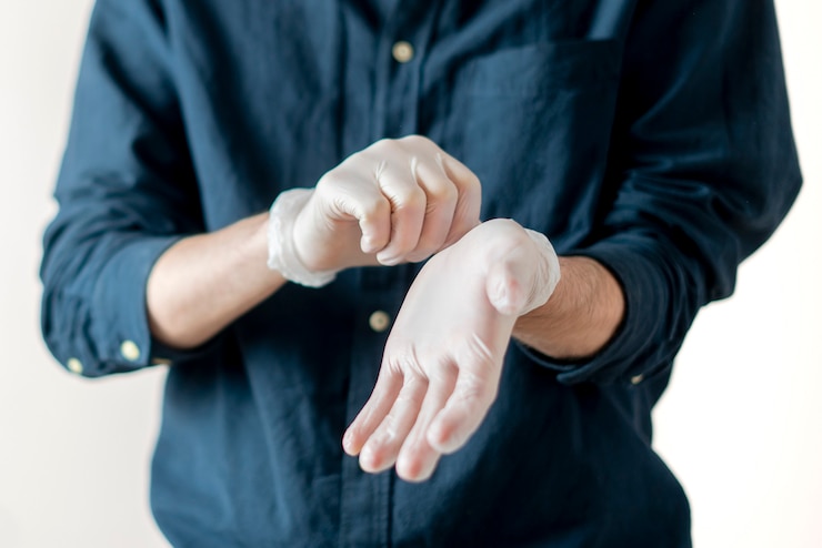 Foto una persona cercana intenta ponerse guantes protectores en las manos para protegerse de la epidemia de coronavidus