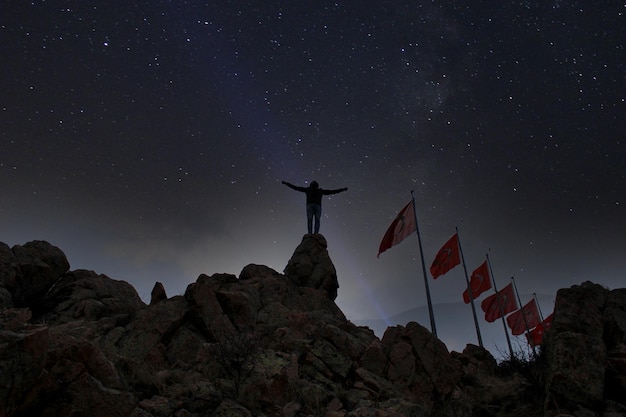 Una persona se para en la cima de una montaña con una bandera que dice tongariro.