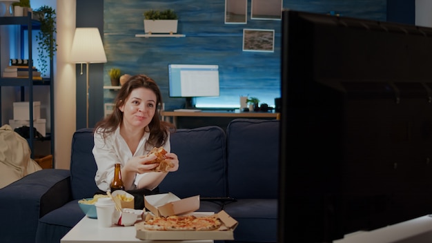 Persona comiendo deliciosas hamburguesas y papas fritas en el salón