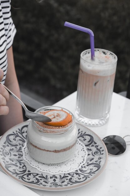 Foto una persona está comiendo un postre de un frasco con una pajita en él